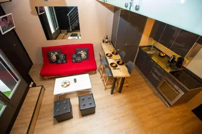 a living room with a red couch and a table at Les Barrats - Duplex - Central - Vue Mont-Blanc in Chamonix-Mont-Blanc