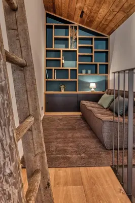 a living room with a couch and a book shelf at Chalet Choucas - Modern Luxury - Heart of Chamonix in Chamonix-Mont-Blanc