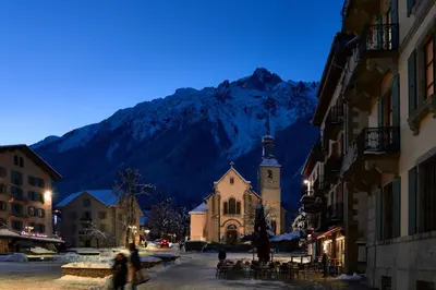 a town with a church and a mountain in the background at Chalet Choucas - Modern Luxury - Heart of Chamonix in Chamonix-Mont-Blanc