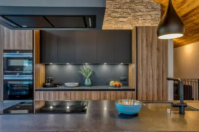 a kitchen with black cabinets and a counter top at Chalet Choucas - Modern Luxury - Heart of Chamonix in Chamonix-Mont-Blanc