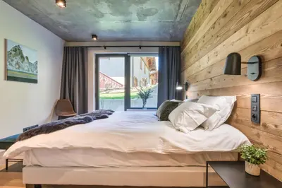 a bedroom with a large bed and a window at Chalet Choucas - Modern Luxury - Heart of Chamonix in Chamonix-Mont-Blanc