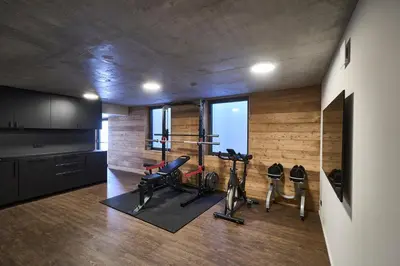 a gym with treadmills and exercise equipment in a room at Chalet Choucas - Modern Luxury - Heart of Chamonix in Chamonix-Mont-Blanc
