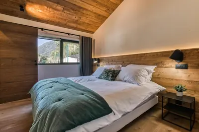 a bedroom with a large bed and a window at Chalet Choucas - Modern Luxury - Heart of Chamonix in Chamonix-Mont-Blanc
