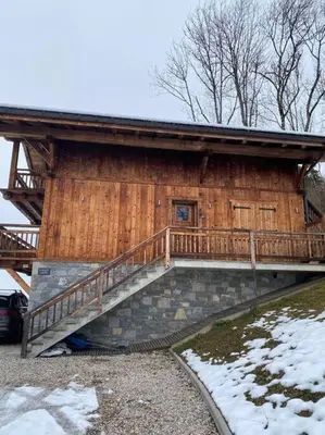 a wooden cabin with a staircase in front of it at Chalet Aspre in Samoëns