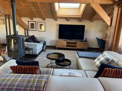 a living room with couches and a flat screen tv at Chalet Aspre in Samoëns