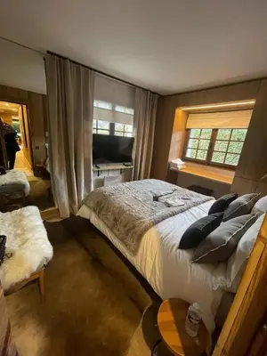 a bedroom with a large bed and a window at Appartement chaleureux à Megève - 80 m² avec jardin et cheminée. in Megève