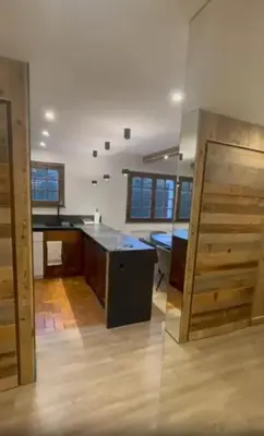 an empty room with a kitchen with a counter top at Appartement chaleureux à Megève - 80 m² avec jardin et cheminée. in Megève
