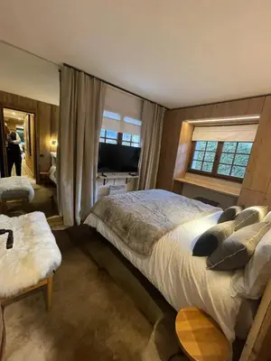 a bedroom with a large bed and a large window at Appartement chaleureux à Megève - 80 m² avec jardin et cheminée. in Megève