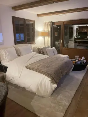 a bedroom with a large bed and a couch at Appartement chaleureux à Megève - 80 m² avec jardin et cheminée. in Megève