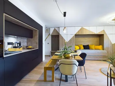 a kitchen and living room with a dining table and a bed at Panorama MontBlanc in Domancy
