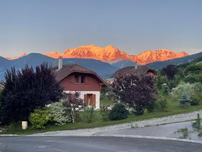 a house on the side of a road with mountains in the background at Panorama MontBlanc in Domancy