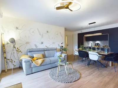 a living room with a blue couch and a kitchen at Panorama MontBlanc in Domancy