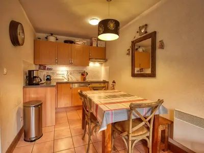 a kitchen with a table with chairs and a counter top at Bel appartement skis aux pieds à Morillon 1100 - 4 à 6 personnes - FR-1-642-94 in Morillon