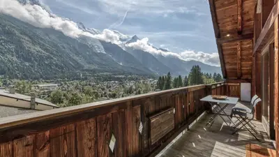 a balcony with a table and a view of mountains at Ferme des Moussoux in Chamonix-Mont-Blanc