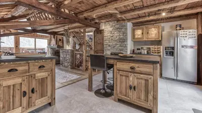 a kitchen with wooden cabinets and a refrigerator at Ferme des Moussoux in Chamonix-Mont-Blanc