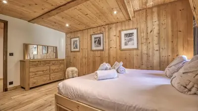 a bedroom with wooden walls and a large bed at Ferme des Moussoux in Chamonix-Mont-Blanc