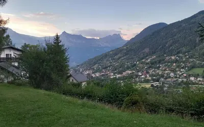 a town on a hill with mountains in the background at Appartement à la Montagne in Saint-Gervais-les-Bains