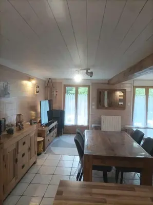 a living room with a wooden table and a kitchen at Appartement à la Montagne in Saint-Gervais-les-Bains