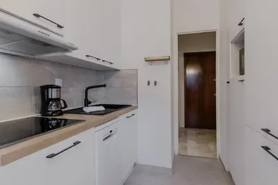 a kitchen with white cabinets and a sink at Appt Laltimetre - Jardin - Skis aux pieds in Chamonix-Mont-Blanc