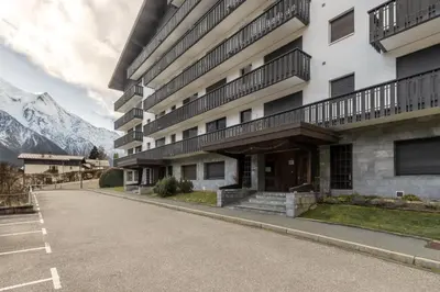an empty street in front of a building with mountains at Appt Laltimetre - Jardin - Skis aux pieds in Chamonix-Mont-Blanc