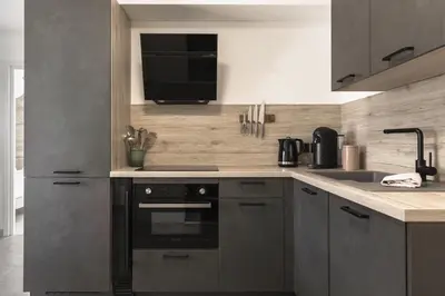 a kitchen with a black oven and a sink at Apartment Léo -Espace bien-être -Piscine in Les Houches