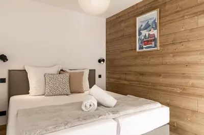 a bedroom with a bed with a wooden wall at Apartment Léo -Espace bien-être -Piscine in Les Houches