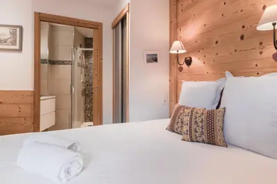 a bedroom with a white bed and a shower at Grand Paradis in Chamonix-Mont-Blanc