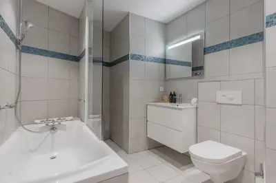 a white bathroom with a toilet and a sink at Grand Paradis in Chamonix-Mont-Blanc