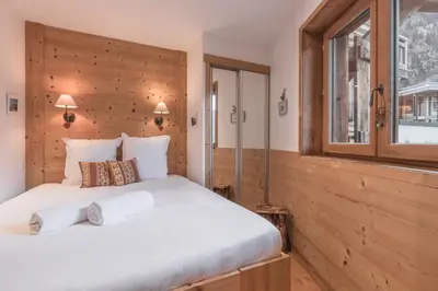 a bedroom with a large white bed and a window at Grand Paradis in Chamonix-Mont-Blanc