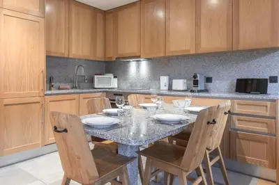 a kitchen with a table with chairs and a counter at Grand Paradis in Chamonix-Mont-Blanc