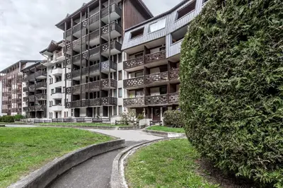 an apartment building with a large bush next to a street at Grepon Paradis - Chamonix - Proche Aiguille Midi in Chamonix-Mont-Blanc