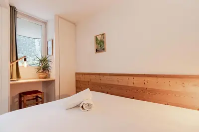 a bedroom with a white bed and a window at Grepon Paradis - Chamonix - Proche Aiguille Midi in Chamonix-Mont-Blanc