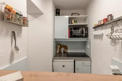a small kitchen with white cabinets and a microwave at Grepon Paradis - Chamonix - Proche Aiguille Midi in Chamonix-Mont-Blanc