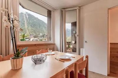 a dining room with a table and a large window at Grepon Paradis - Chamonix - Proche Aiguille Midi in Chamonix-Mont-Blanc
