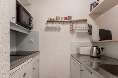 a kitchen with white cabinets and a counter top at Grepon Paradis - Chamonix - Proche Aiguille Midi in Chamonix-Mont-Blanc