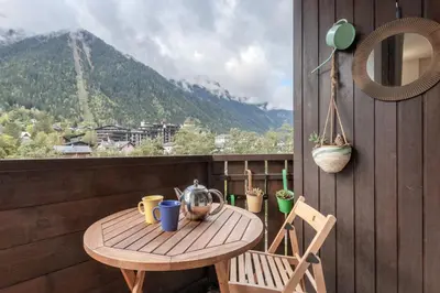 a table and chairs on a balcony with a view of a mountain at Grepon Paradis - Chamonix - Proche Aiguille Midi in Chamonix-Mont-Blanc