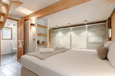 a bedroom with a large white bed with glass doors at La Bastide - Grand chalet privé - Quartier calme in Les Houches