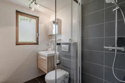 a bathroom with a toilet and a glass shower at La Bastide - Grand chalet privé - Quartier calme in Les Houches