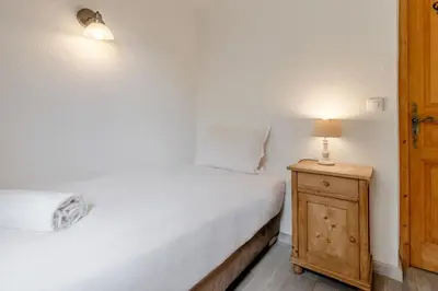 a bedroom with a bed and a lamp on a night stand at La Bastide - Grand chalet privé - Quartier calme in Les Houches