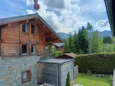 a log house with a solarium on the side of it at La Ferme du Lay in Arâches-la-Frasse