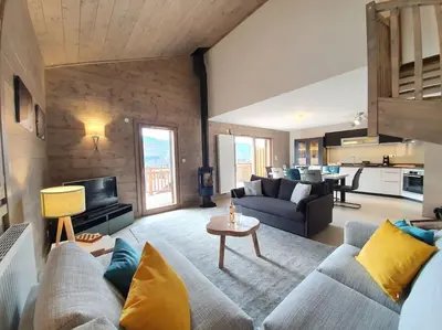 a living room with a couch and a table at Samoens - luxury 4 bedroom top floor apartment with spectacular views in Samoëns