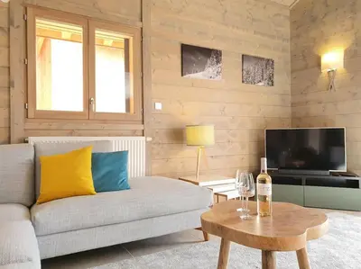 a living room with a couch and a table at Samoens - luxury 4 bedroom top floor apartment with spectacular views in Samoëns