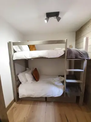 a room with three bunk beds in a room at Samoens - luxury 4 bedroom top floor apartment with spectacular views in Samoëns