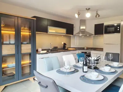 a kitchen with a white table and chairs and a kitchen with at Samoens - luxury 4 bedroom top floor apartment with spectacular views in Samoëns