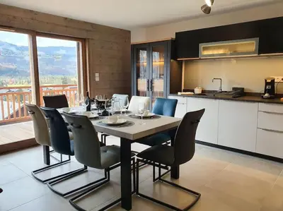 a kitchen and dining room with a table and chairs at Samoens - luxury 4 bedroom top floor apartment with spectacular views in Samoëns