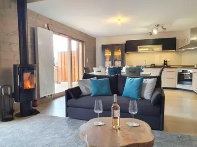 a living room with a couch and a table with wine glasses at Samoens - luxury 4 bedroom top floor apartment with spectacular views in Samoëns