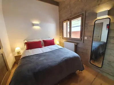 a bedroom with a large bed with two red pillows at Samoens - luxury 4 bedroom top floor apartment with spectacular views in Samoëns