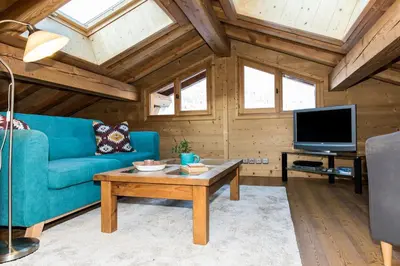a living room with a staircase and a couch at Chalet Les Drus Luxurious Chalet With Breathtaking Mont Blanc Views From Hot Tub and Garden in Les Houches