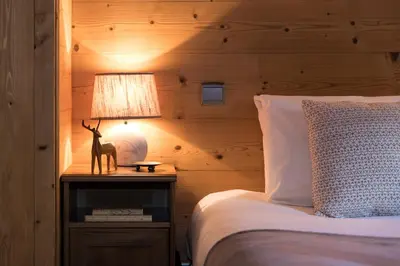 a living room with a blue couch and a tv at Chalet Les Drus Luxurious Chalet With Breathtaking Mont Blanc Views From Hot Tub and Garden in Les Houches