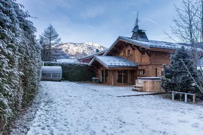 a kitchen with wooden cabinets and a stove top oven at Chalet Les Drus Luxurious Chalet With Breathtaking Mont Blanc Views From Hot Tub and Garden in Les Houches